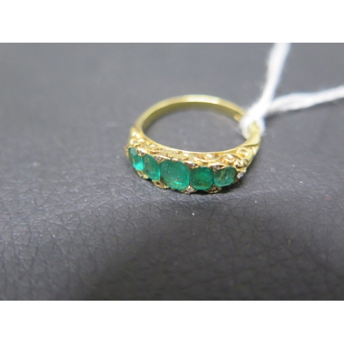 117 - An 18ct yellow gold emerald bridge ring with five graduated emeralds with diamond chips - ring size ... 