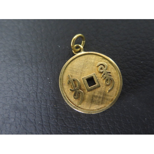 129 - A 14ct yellow gold pendant with Chinese characters - approx 1.8cm - weight approx 2.5 grams with two... 