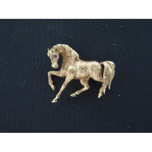 174 - An 18ct yellow gold brooch of a horse set with ruby eyes - approx 3cm - weight approx 7.5grams