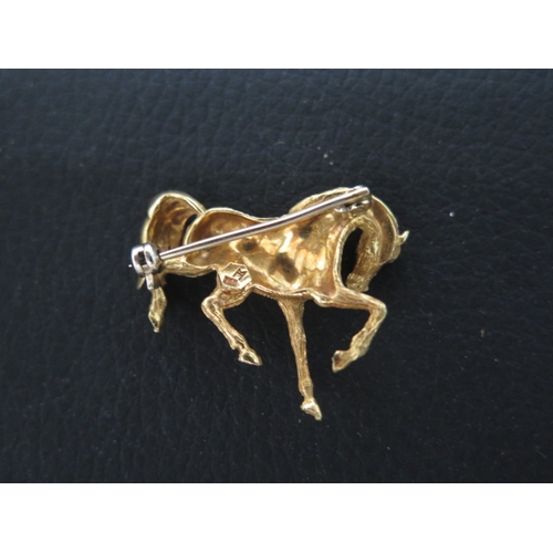 174 - An 18ct yellow gold brooch of a horse set with ruby eyes - approx 3cm - weight approx 7.5grams