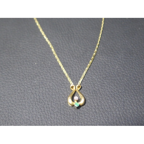 196 - A 9ct yellow gold pendant and chain, lyre shaped pendant with emerald and diamond accent approx 1.5c... 