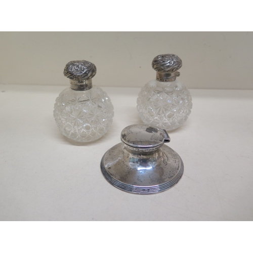 288 - Two cut glass silver topped scent bottles - approx 10cm - together with a silver inkwell - approx 9c... 