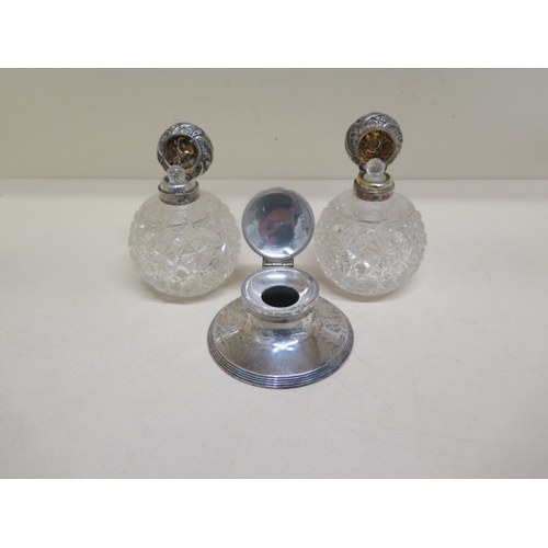 288 - Two cut glass silver topped scent bottles - approx 10cm - together with a silver inkwell - approx 9c... 