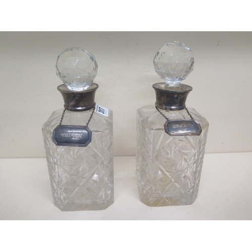 317 - A pair of silver topped cut glass decanters with silver Brandy and Whisky labels - one decanter with... 