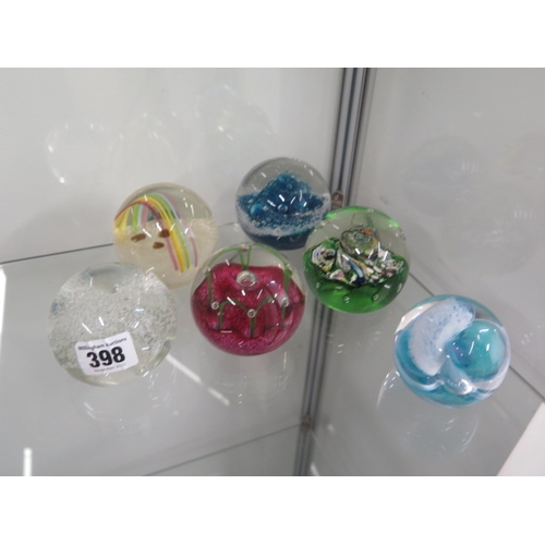 398 - Six glass paperweights ranging from 6cm to 8cm