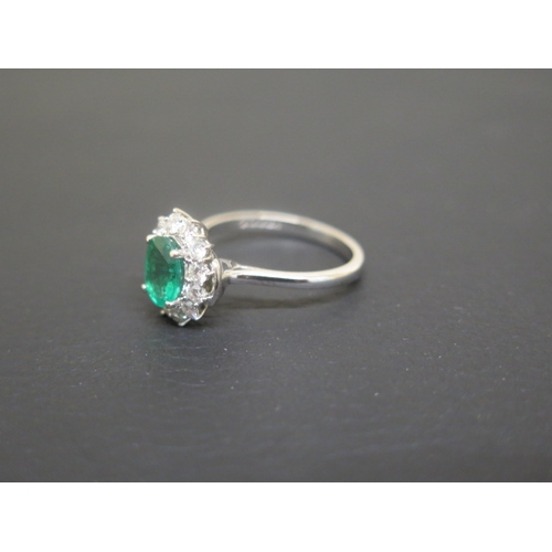 173 - A good emerald and diamond cluster ring - The oval central stone approx 1.5ct and surrounded by 12 b... 