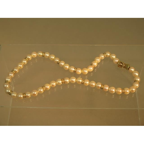 103 - A single string of pearls with 14ct (hallmarked) yellow gold clasp with diamonds, pearls divided wit... 