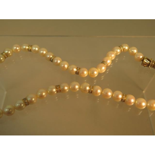 103 - A single string of pearls with 14ct (hallmarked) yellow gold clasp with diamonds, pearls divided wit... 