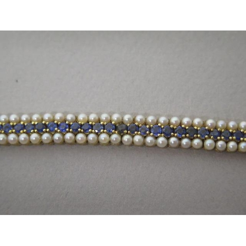 112 - A very good flexible bracelet set with a central row of 60 blue sapphires bordered by two rows of pe... 