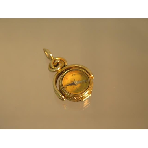 143 - An unusual 9ct (tested) yellow gold swivel fob set with compass (working) finely chased case hinged ... 