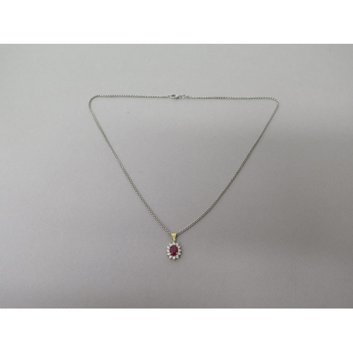 160 - A ruby and diamond cluster pendant in 18ct (hallmarked) gold - approx 2cm inc ring - on an 18ct (hal... 