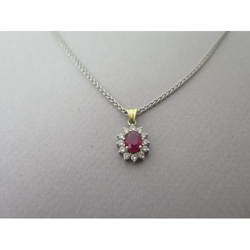 160 - A ruby and diamond cluster pendant in 18ct (hallmarked) gold - approx 2cm inc ring - on an 18ct (hal... 