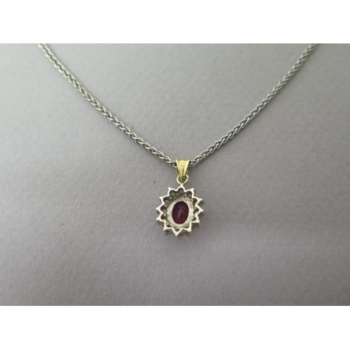 160 - A ruby and diamond cluster pendant in 18ct (hallmarked) gold - approx 2cm inc ring - on an 18ct (hal... 