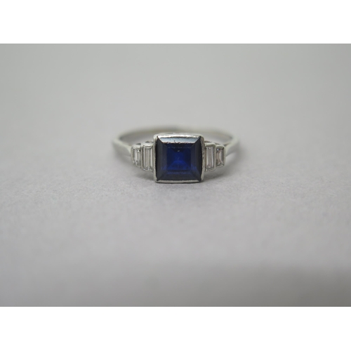 182 - A platinum (hallmarked) sapphire and diamond ring - the central square sapphire approx 6mm with bagu... 