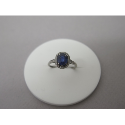 207 - An Art Deco sapphire and diamond ring set in platinum (hallmarked)  the central oval sapphire surrou... 