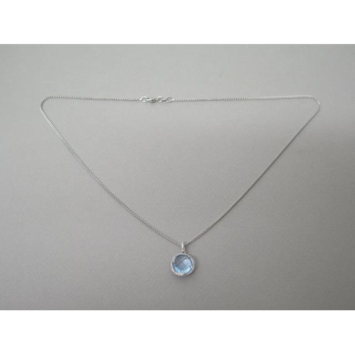 211 - A blue topaz and diamond pendant on chain set in 18ct white gold (hallmarked) chequer board cut roun... 