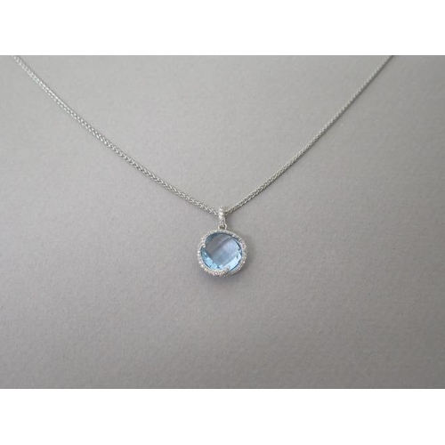 211 - A blue topaz and diamond pendant on chain set in 18ct white gold (hallmarked) chequer board cut roun... 