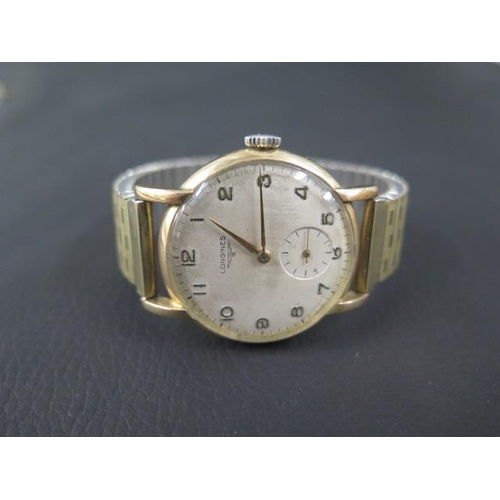 275 - A gents 9ct gold Longines wristwatch with a plated strap and seconds hand - in working order