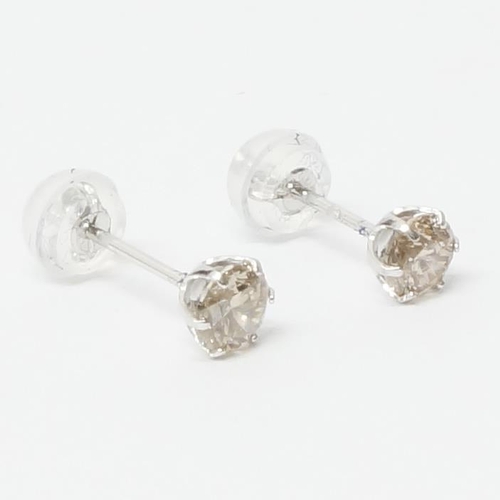 A pair of platinum 6-claw set diamond studs with rubber-capped ...