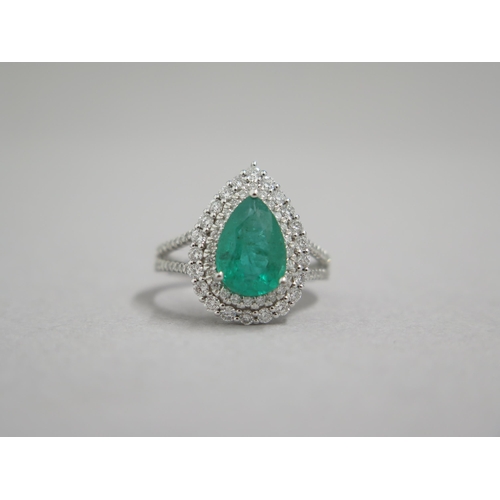 111 - A stunning 18ct white gold (hallmarked) emerald and diamond ring, the central pear shaped emerald ap... 