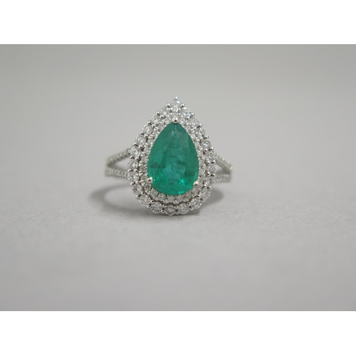 111 - A stunning 18ct white gold (hallmarked) emerald and diamond ring, the central pear shaped emerald ap... 