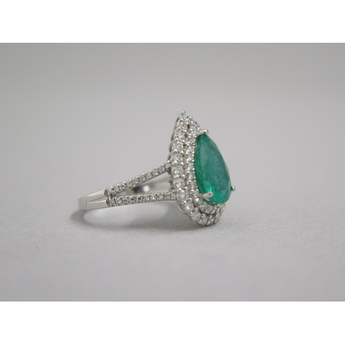 111 - A stunning 18ct white gold (hallmarked) emerald and diamond ring, the central pear shaped emerald ap... 