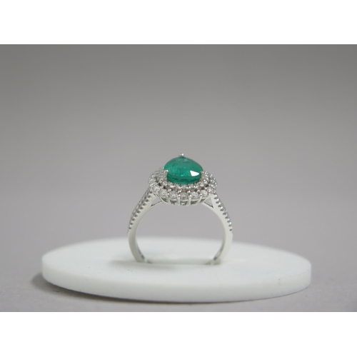 111 - A stunning 18ct white gold (hallmarked) emerald and diamond ring, the central pear shaped emerald ap... 