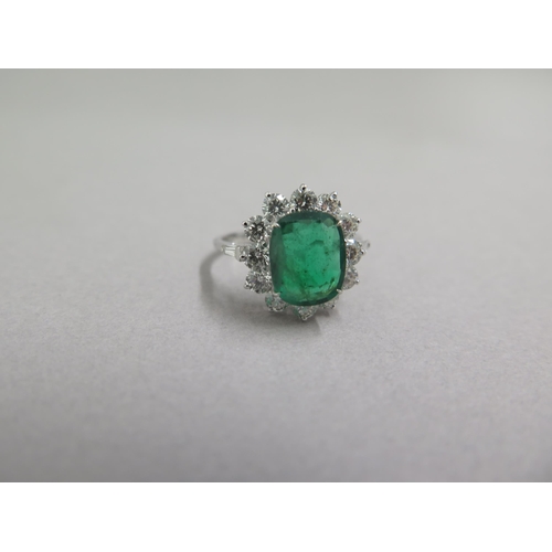 89 - An 18ct white gold ring set with oval cushion emerald and a halo of round brilliant cut diamonds, wi... 