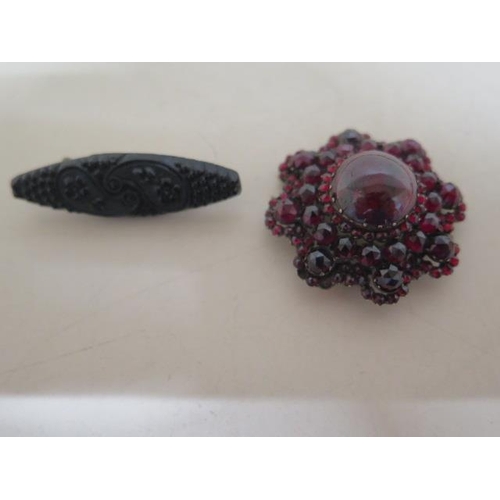 163 - A Victorian cabochon and cut garnet brooch on gilt metal pin, broken - approx 4cm - together with a ... 