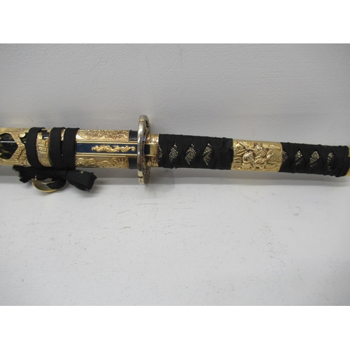 444 - A modern Japanese Katana sword, edged blade approx 70cm with black and gold lacquered gilt metal mou... 