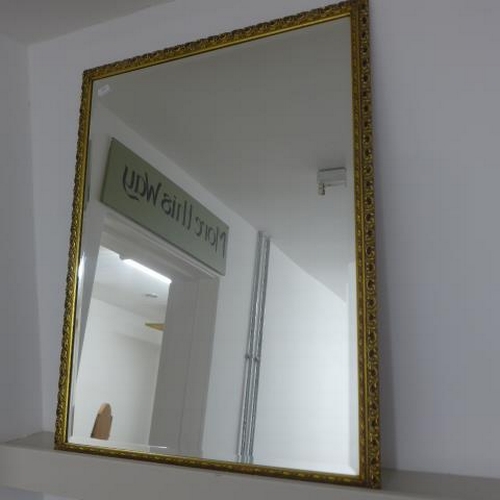 506 - A gilt ornamental mirror with bevelled edge glass, 97cm x 76cm