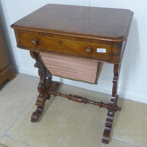 514 - A Victorian burr walnut workbox with a fitted drawer and basket on shaped fretted supports united by... 