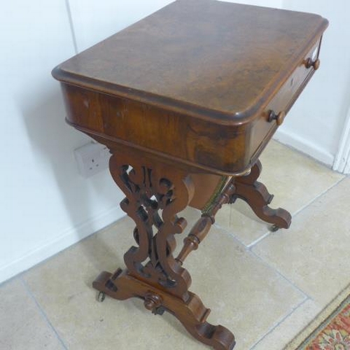 514 - A Victorian burr walnut workbox with a fitted drawer and basket on shaped fretted supports united by... 