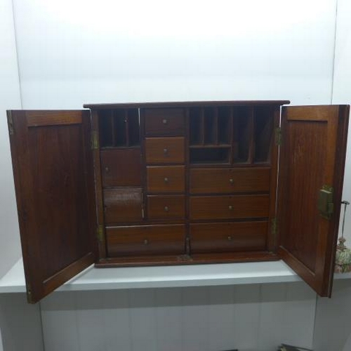 517 - A late 19th/early 20th century walnut cabinet with a fitted interior with drawers and pigeons holes