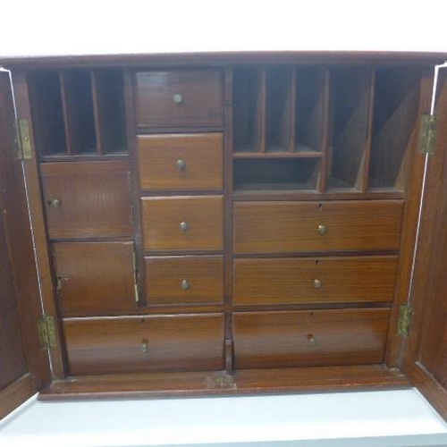 517 - A late 19th/early 20th century walnut cabinet with a fitted interior with drawers and pigeons holes