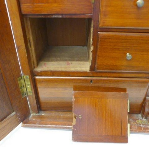 517 - A late 19th/early 20th century walnut cabinet with a fitted interior with drawers and pigeons holes