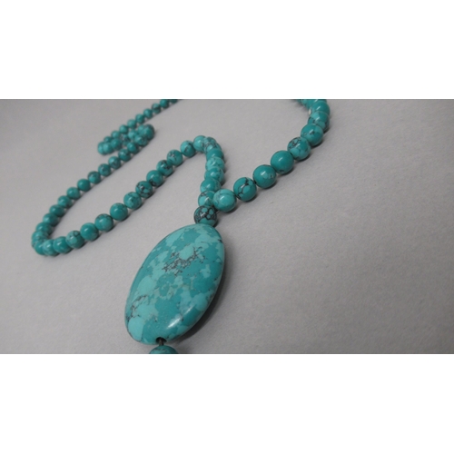 184 - A string of natural turquoise beads with a drop pendant - beads approx 8mm diameter x 86cm long, dro... 