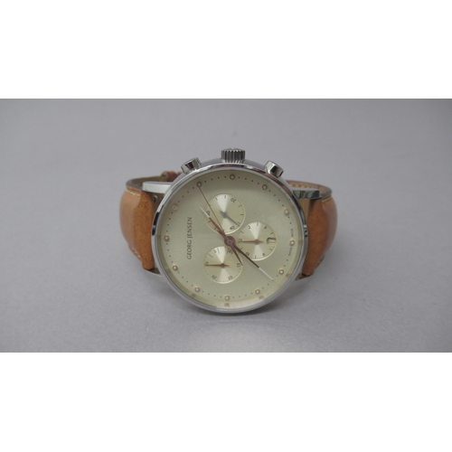 255 - A Georg Jensen quartz chronograph wristwatch, champagne dial, with box and papers, original tan leat... 