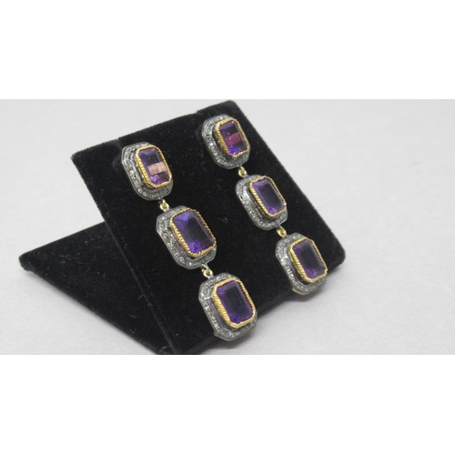 77 - A striking pair of silver-gilt drop earrings each set with 3 emerald-cut amethysts, each surrounded ... 