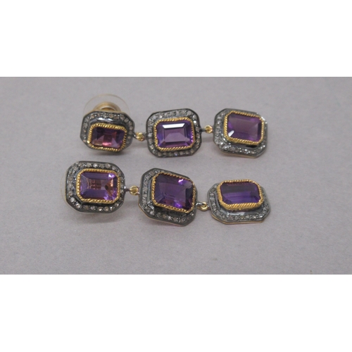 77 - A striking pair of silver-gilt drop earrings each set with 3 emerald-cut amethysts, each surrounded ... 