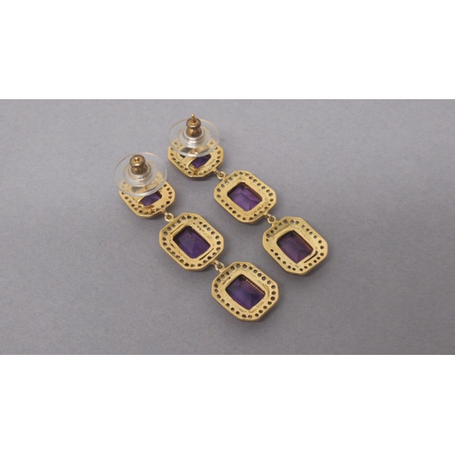 77 - A striking pair of silver-gilt drop earrings each set with 3 emerald-cut amethysts, each surrounded ... 