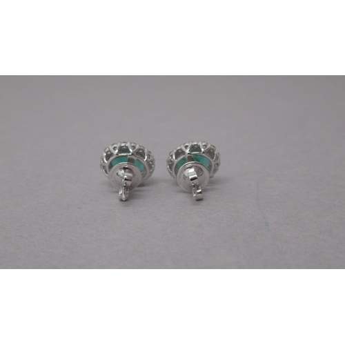 87 - A pair of 18ct white gold oval emerald and round brilliant cut diamond cluster studs, boxed - Emeral... 