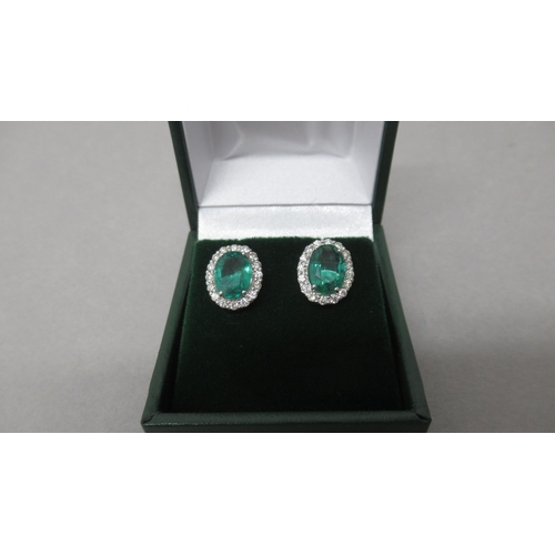 87 - A pair of 18ct white gold oval emerald and round brilliant cut diamond cluster studs, boxed - Emeral... 