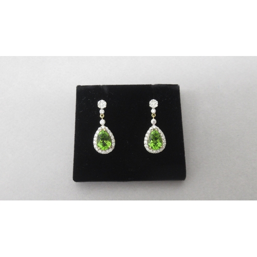 88 - A pair of 18ct yellow gold drop earrings set with pear shaped peridot and round brilliant cut diamon... 