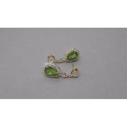 88 - A pair of 18ct yellow gold drop earrings set with pear shaped peridot and round brilliant cut diamon... 