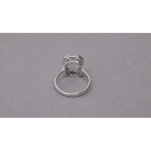 98 - An 18ct white gold ring set with a central emerald-cut aquamarine, with surrounding princess-cut dia... 