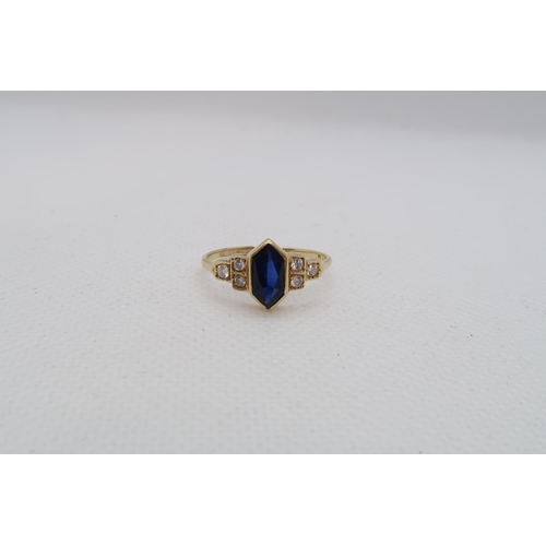 127 - A sapphire (possibly synthetic) ring set in yellow gold (tested as approx 18ct) with diamond set sho... 