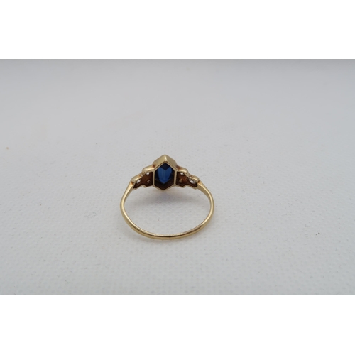 127 - A sapphire (possibly synthetic) ring set in yellow gold (tested as approx 18ct) with diamond set sho... 