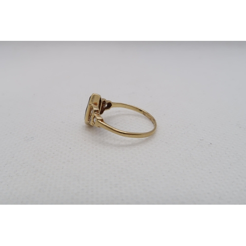 127 - A sapphire (possibly synthetic) ring set in yellow gold (tested as approx 18ct) with diamond set sho... 