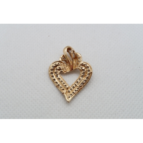 151 - A 14ct yellow gold (hallmarked) heart shaped pendant set with round and baguette diamonds - approx 3... 